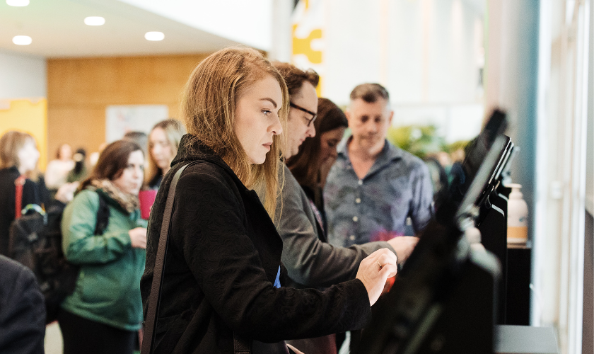 An attendee checking in at a self-check-in kiosk to MEETINGS 2025 - New Zealand's premier tradeshow for the Meetings, Incentives, Conferences, Exhibitions, MICE, Business Events industry